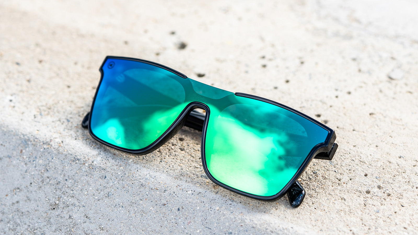 Sunglasses with a black frame with polarized green lenses, flyover