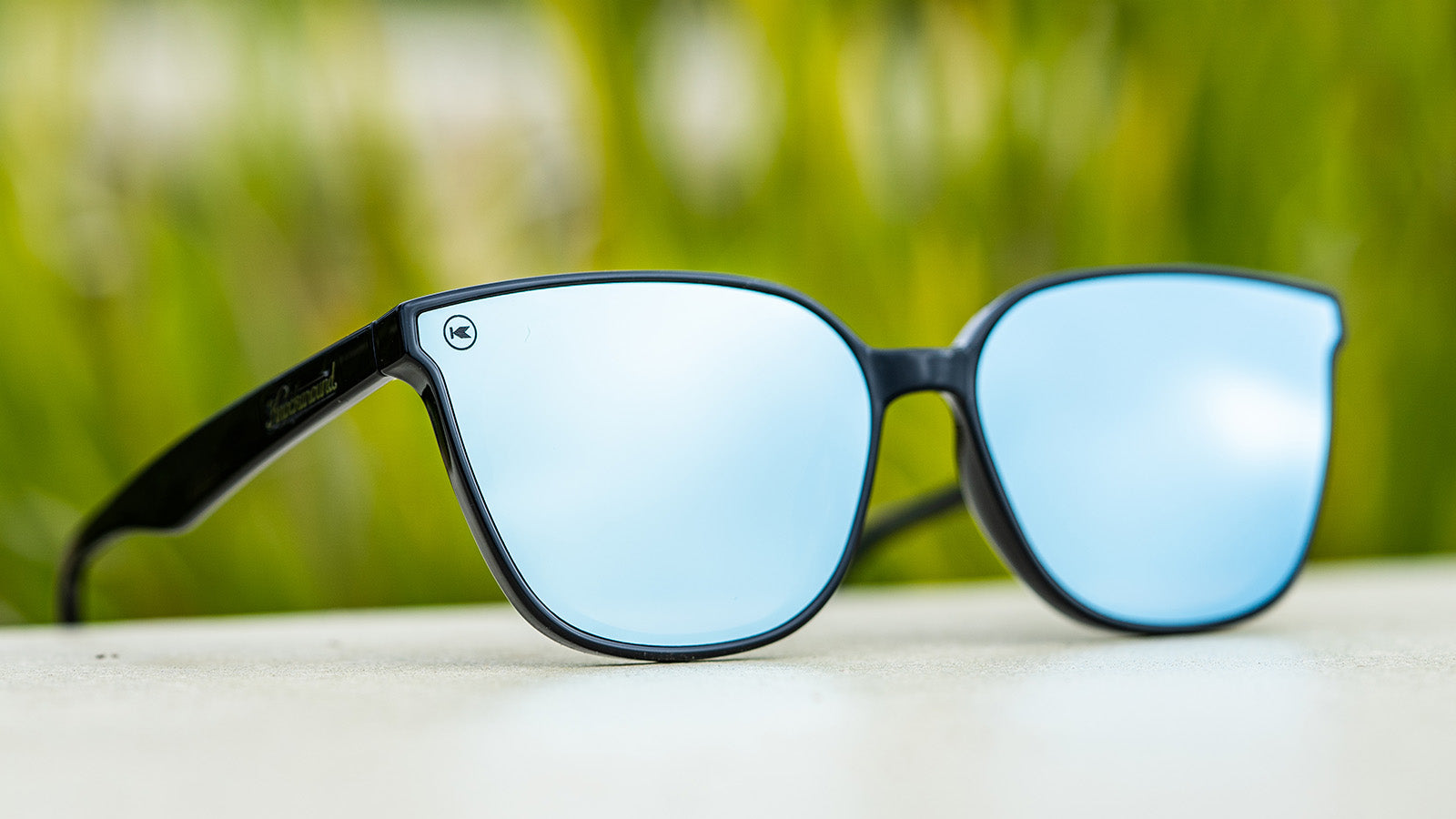Sunglasses with a black frame with polarized blue lenses, flyover