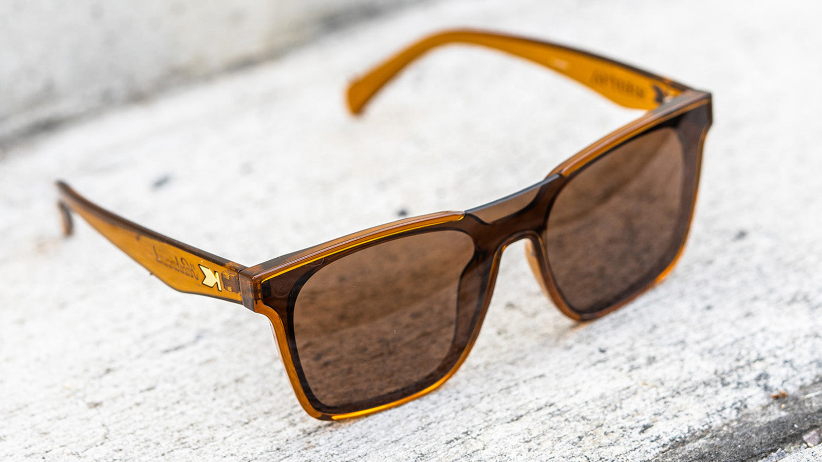 Sunglasses with an amber frame with polarized amber lenses, flyover