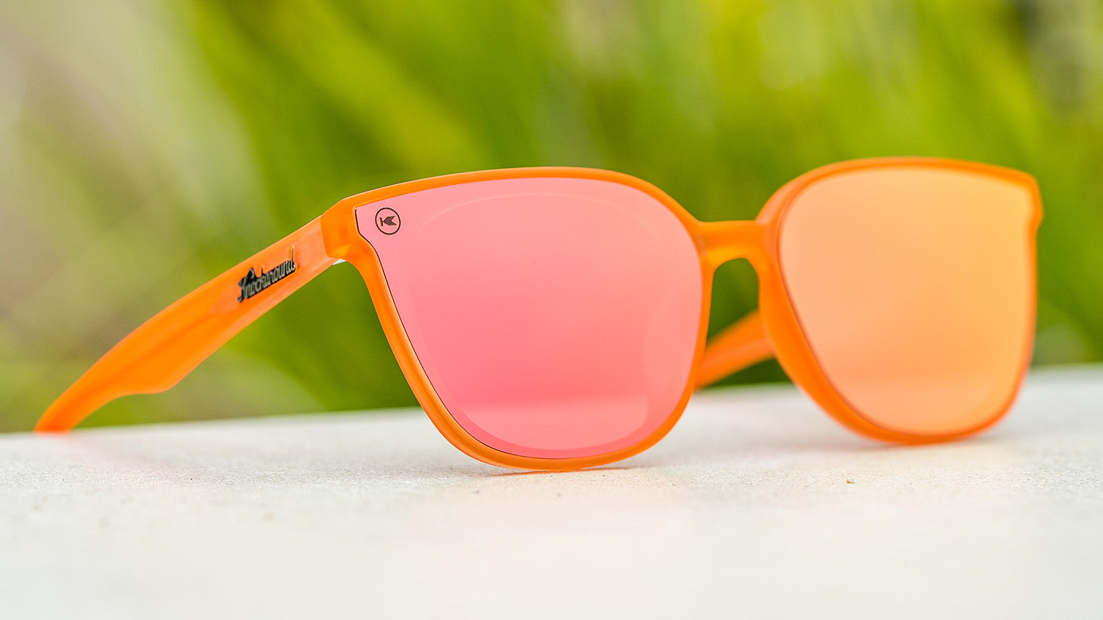 Sunglasses with an orange frame with polarized orange lenses, flyover